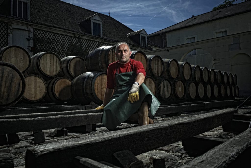 Drink photography of a man in front of barrels - Hospitality Photographic